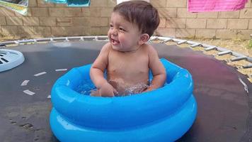 lindo bebé asiático paquistaní de 1 año está disfrutando en la bañera de agua. video