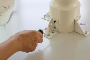 Asian man assembling white table furniture at home photo