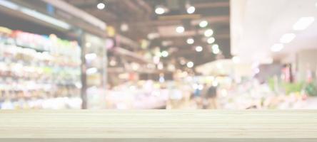 mesa de madera con fondo borroso de la tienda de comestibles del supermercado con luz bokeh para la exhibición del producto foto