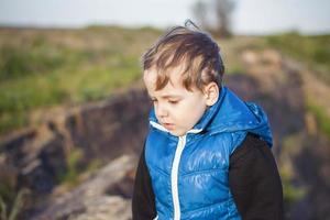 A child stands on top of a cliff and watches what is happening below. panoramic view from the top of a rocky mountain. Russia, Rostov region, skelevataya skala, the 7th wonder of the Don world. photo