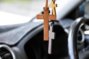 Necklaces of various shapes of crosses are hung in the rearview mirror in the front console of the car as a talisman to prevent accidents while driving. photo