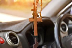 Necklaces of various shapes of crosses are hung in the rearview mirror in the front console of the car as a talisman to prevent accidents while driving. photo