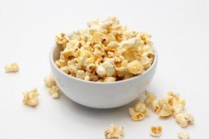 Snack concept, Sweet popcorn in white bowl and falling on white background photo