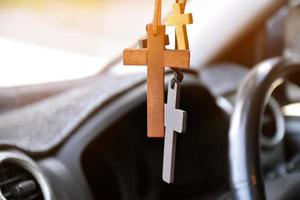 collares de varias formas de cruces se cuelgan en el espejo retrovisor en la consola delantera del automóvil como un talismán para prevenir accidentes durante la conducción. foto