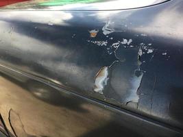 The outside surface of the car's paint is cracked due to deterioration and scratches from various accidents. photo