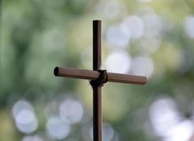 Cross made from wooden pencil with bokeh background. photo