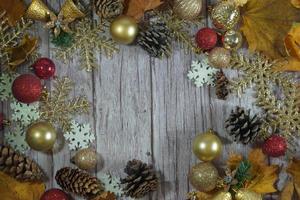 Red and gold Christmas ornament corner border banner. Above view on a rustic wood background. photo