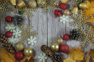 Red and gold Christmas ornament corner border banner. Above view on a rustic wood background. photo