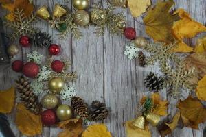 Red and gold Christmas ornament corner border banner. Above view on a rustic wood background. photo