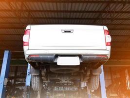 Rear of a pickup truck on a lift while being serviced at a garage, soft and selective focus. photo