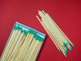 Large matches with green heads on a red background. photo