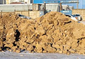 Blocks of frozen earth. A pile of earth.  The consequences of digging a hole with an excavator photo