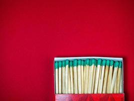 Large matches with green heads on a red background. photo