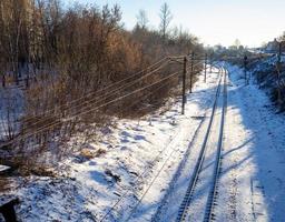 vías del tren en la nieve. ferrocarril en invierno foto