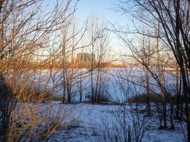 paisaje de invierno puesta de sol sobre el río helado. foto