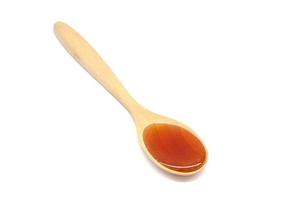 Honey in wooden spoon has a sweet taste isolated on white background. photo