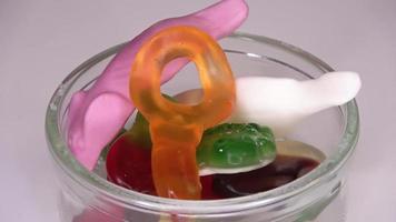 A selection of colourful wine gum sweets in a glass bowl slowly rotates in a circle - loop able video. video