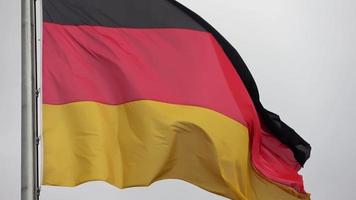 una bandera de alemania ondeando lentamente en el viento en un asta de bandera. video