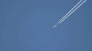 straalvliegtuig dat hoog in de lucht vliegt en contrails achterlaat in de heldere blauwe lucht. video