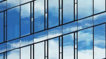 laps de temps d'un ciel d'été bleu avec des nuages se reflétant sur la façade en verre d'un immeuble de bureaux video