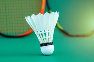 white shuttlecock on green background blurred badminton racket background. soft and selective focus. photo