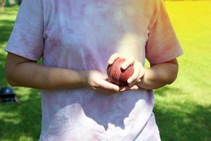 Asian female players hold clicket ball in hand while practicing for the first time on the grass field. photo