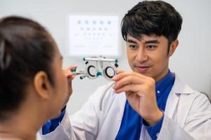 enfoque selectivo en la cara de las mujeres. mientras que el médico usa equipo de optometría y marco de anteojos de prueba para examinar el sistema visual de las mujeres mayores con máquina y técnica profesional. foto