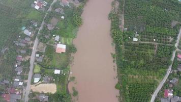 Aerial view of the river flowing after heavy rain and flooding of fields in rural villages. Top view of agricultural areas affected by rainy season floods. Climate change concept video