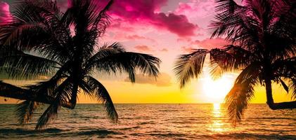 hermosa playa tropical al atardecer con palmeras y cielo rosa para viajes y vacaciones en tiempo de relajación de vacaciones foto