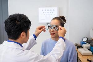 enfoque selectivo en la cara de las mujeres. mientras que el médico usa equipo de optometría y marco de anteojos de prueba para examinar el sistema visual de las mujeres mayores con máquina y técnica profesional. foto