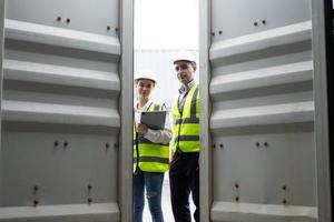 Caucasian men and women freight  supervisor wearing safety vest and hat while inspect condition of all containers shipment, People and worker in freight deliver, import and export. photo