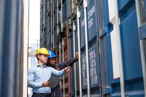 Selective focus at African black worker while talk and having discussion with supervisor and inspect the condition of all containers shipment, People and worker in freight deliver, import and export. photo