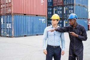 Selective focus at African black worker while talk and having discussion with supervisor and inspect the condition of all containers shipment, People and worker in freight deliver, import and export. photo