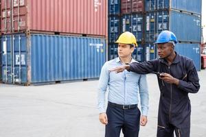 Enfoque selectivo en el trabajador negro africano mientras habla y discute con el supervisor e inspecciona el estado de todos los envíos de contenedores, personas y trabajadores en la entrega, importación y exportación de mercancías. foto