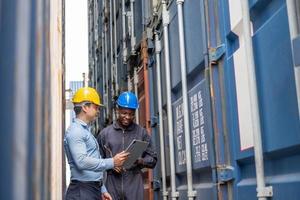 Selective focus at African black worker while talk and having discussion with supervisor and inspect the condition of all containers shipment, People and worker in freight deliver, import and export.