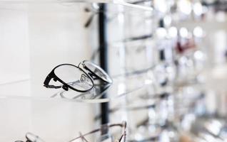 Selective focus at glasses frame on the shelf inside of the store for customer choice and selection. With different color and style. Optometrist and eye vision store or business. photo