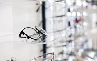 Selective focus at glasses frame on the shelf inside of the store for customer choice and selection. With different color and style. Optometrist and eye vision store or business. photo