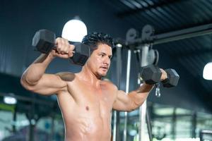 Handsome adult Caucasian men sweating while lift up the dumbbell workout for arm biceps muscle part inside of fitness gym. Bodybuilding athlete sport training for body strength and good health. photo