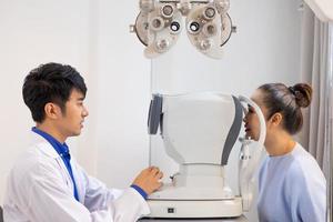 Selective focus at Optometry frame equipment. While doctor using penlight and subjective refraction to  examine eye visual system of elder patient women with professional machine before made glasses. photo