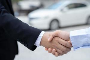 Salesman is carrying the car keys delivered to the customer at the showroom with a low interest offer. Special promotion photo