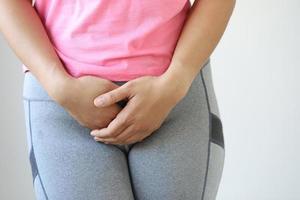 primer plano de una dama rosa con muchos calambres menstruales en el dormitorio. foto