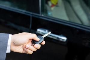 Salesman is carrying the car keys delivered to the customer at the showroom with a low interest offer. Special promotion photo
