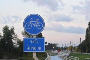 Señal de carretera de carril bici azul con idiomas tailandeses en el parque. foto