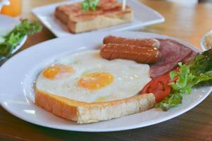 desayuno americano completo con huevos, salchichas de tocino y vegetales, enfoque selectivo. foto