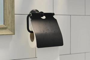 Close-up of black toilet roll holder in bathroom. photo