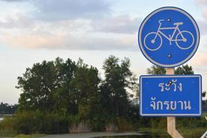 Señal de carretera de carril bici azul con idiomas tailandeses en el parque. foto