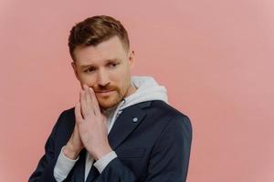 Portrait of worriend young man on pink background photo