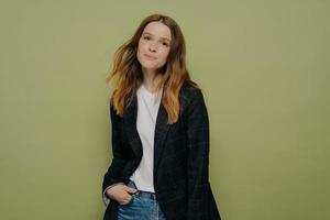 Lovely young female posing with hand in pocket on color background photo