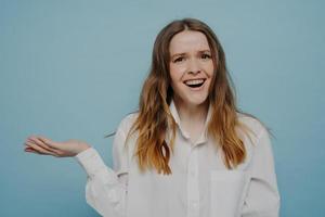 Happy young woman in white shirt presenting something on hand photo