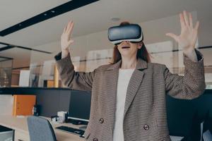 mujer sorprendida experimentando el increíble mundo de la realidad virtual con gafas vr en el trabajo foto